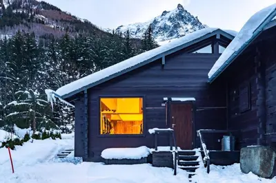 a log cabin in the snow with a window at Yagire - Charmant Mazot 4pax HomeCine Nature Terrasse in Chamonix-Mont-Blanc