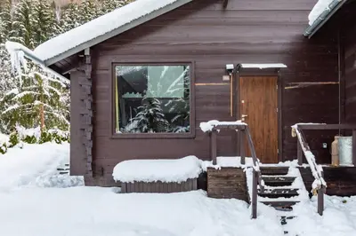 a cabin with snow on the porch and a door at Yagire - Charmant Mazot 4pax HomeCine Nature Terrasse in Chamonix-Mont-Blanc