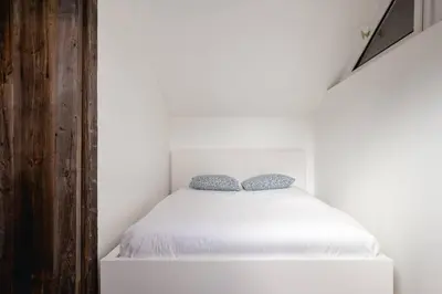 a bedroom with a white bed with two blue pillows at Yagire - Charmant Mazot 4pax HomeCine Nature Terrasse in Chamonix-Mont-Blanc