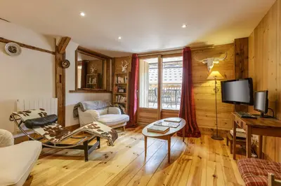 a living room with a couch and a tv at Ferme d Aristide - Chalet 160m2 Calme Sauna Vue Bus Train 250m in Chamonix-Mont-Blanc