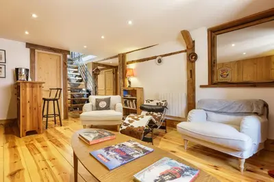 a living room with a couch and a table at Ferme d Aristide - Chalet 160m2 Calme Sauna Vue Bus Train 250m in Chamonix-Mont-Blanc