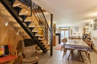 a dining room with a table and a staircase at Ferme d Aristide - Chalet 160m2 Calme Sauna Vue Bus Train 250m in Chamonix-Mont-Blanc