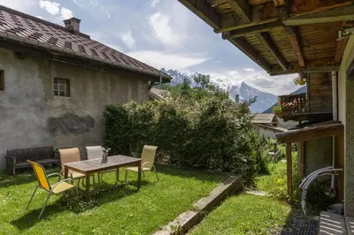 a table and chairs in the yard of a house at Ferme d Aristide - Chalet 160m2 Calme Sauna Vue Bus Train 250m in Chamonix-Mont-Blanc