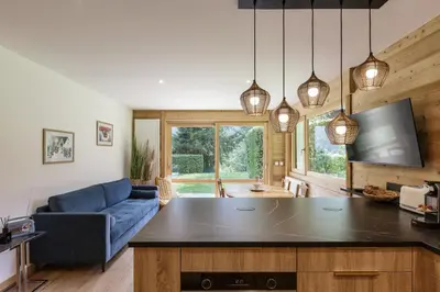 a kitchen with a living room with a blue couch at KV - Moderne 2CH Vue MtBlanc Terrasse Brevent 3mn in Chamonix-Mont-Blanc