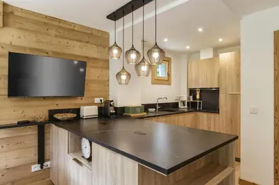 a kitchen with a large counter with a tv at KV - Moderne 2CH Vue MtBlanc Terrasse Brevent 3mn in Chamonix-Mont-Blanc