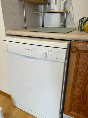 a white dishwasher in a kitchen next to a counter at Studio confortable dans résidence avec piscine in Samoëns