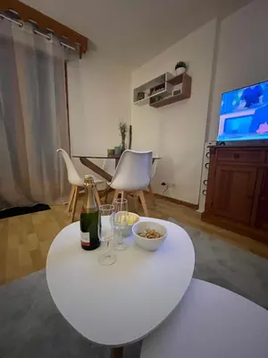 a white table with two glasses and a bottle of wine at Studio confortable dans résidence avec piscine in Samoëns