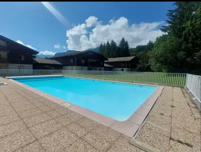 a large swimming pool with a fence around it at Studio confortable dans résidence avec piscine in Samoëns