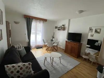 a living room with a couch and a table at Studio confortable dans résidence avec piscine in Samoëns