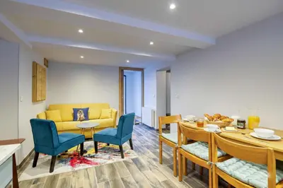 a living room with a yellow couch and a table and chairs at Lou Dava Chic Apt Near Centre Chamonix - Happy Rentals in Chamonix-Mont-Blanc