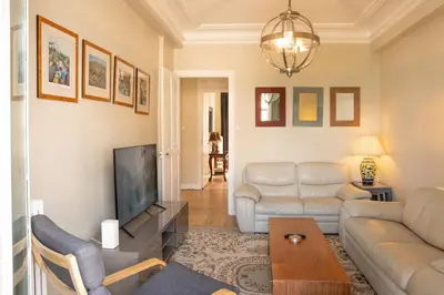 a living room with a couch and a tv at Timeless Elegance, 2 bed Apt in Historical Building St Gervais in Saint-Gervais-les-Bains
