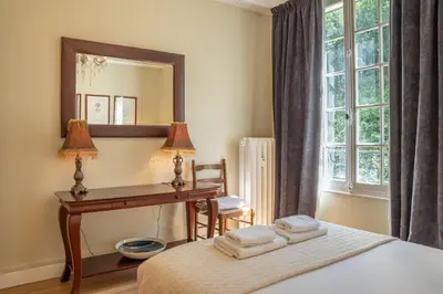 a bedroom with a bed with a desk and a mirror at Timeless Elegance, 2 bed Apt in Historical Building St Gervais in Saint-Gervais-les-Bains