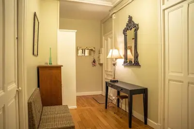 a hallway with a black desk and a mirror at Timeless Elegance, 2 bed Apt in Historical Building St Gervais in Saint-Gervais-les-Bains