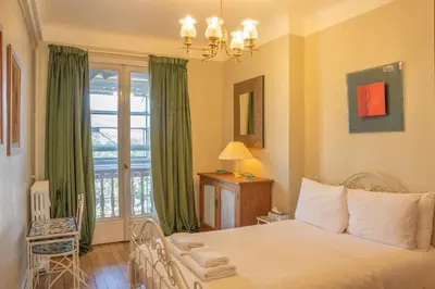 a bedroom with a bed and a window with green curtains at Timeless Elegance, 2 bed Apt in Historical Building St Gervais in Saint-Gervais-les-Bains