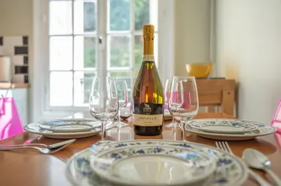 a bottle of wine sitting on a table with glasses at Timeless Elegance, 2 bed Apt in Historical Building St Gervais in Saint-Gervais-les-Bains