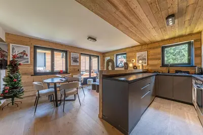 a kitchen and dining room with a christmas tree in it at Lara Megeve Jaillet proche du village Parking in Megève