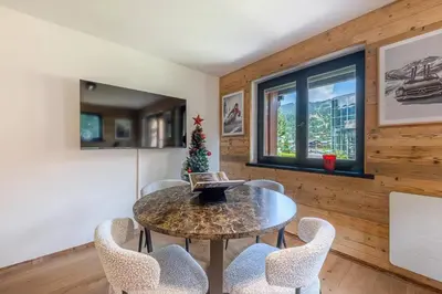 a dining room with a table and chairs at Lara Megeve Jaillet proche du village Parking in Megève