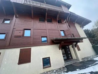 a large building with wooden doors on it at Lara Megeve Jaillet proche du village Parking in Megève