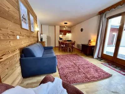a living room with a blue couch and a table at Appartement familial à Samoëns avec piscine et parking - FR-1-624-189 in Samoëns
