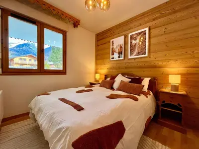 a bedroom with a large bed in a room with wooden walls at Appartement familial à Samoëns avec piscine et parking - FR-1-624-189 in Samoëns