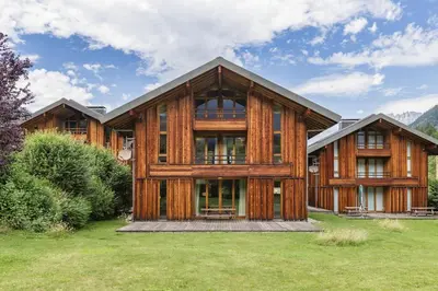 a large wooden house with a green yard at Meleze - Chalet 5CH Vues Jardin Lac Remontees 200m in Les Houches