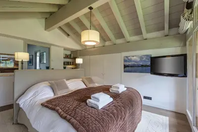 a bedroom with a large bed and a flat screen tv at Meleze - Chalet 5CH Vues Jardin Lac Remontees 200m in Les Houches