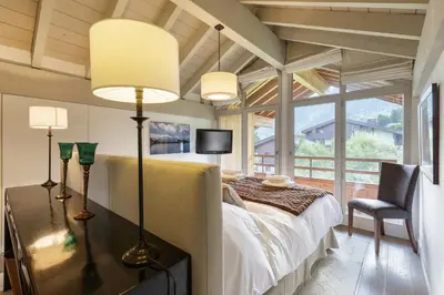 a bedroom with a bed and a desk with a chair at Meleze - Chalet 5CH Vues Jardin Lac Remontees 200m in Les Houches