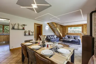 a dining room and living room with a table and chairs at Arve - Chalet 4CH Jardin Nature Vues BBQ Poele in Chamonix-Mont-Blanc