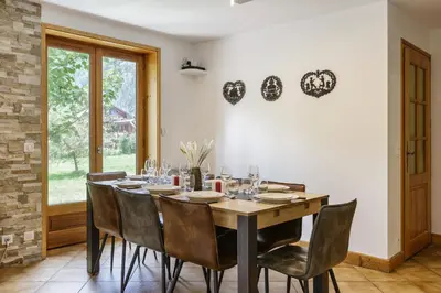 a dining room with a wooden table and chairs at Arve - Chalet 4CH Jardin Nature Vues BBQ Poele in Chamonix-Mont-Blanc