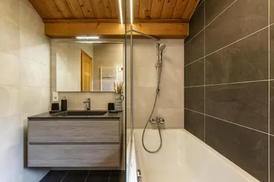 a bathroom with a bath tub and a sink at Arve - Chalet 4CH Jardin Nature Vues BBQ Poele in Chamonix-Mont-Blanc