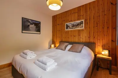 a bedroom with a white bed with towels on it at Arve - Chalet 4CH Jardin Nature Vues BBQ Poele in Chamonix-Mont-Blanc
