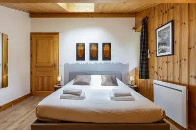 a bedroom with a large bed with two pillows on it at Arve - Chalet 4CH Jardin Nature Vues BBQ Poele in Chamonix-Mont-Blanc