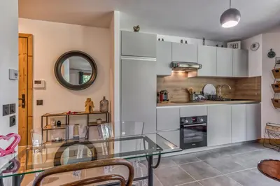 a kitchen with a glass table and a mirror at Turra - Cosy 80m2 Central Remontee Parking Calme in Les Houches