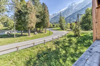 a winding road with mountains in the background at Turra - Cosy 80m2 Central Remontee Parking Calme in Les Houches