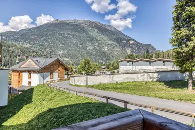 a house with a mountain in the background at Turra - Cosy 80m2 Central Remontee Parking Calme in Les Houches