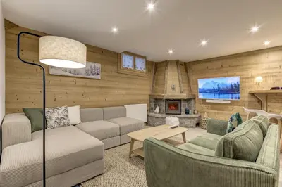 a living room with a couch and a fireplace at Mouilles - Apart 113m2 Jardin Calme Garage Bar Centre in Chamonix-Mont-Blanc