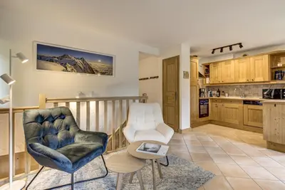 a living room with two chairs and a kitchen at Mouilles - Apart 113m2 Jardin Calme Garage Bar Centre in Chamonix-Mont-Blanc