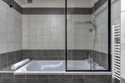 a bathroom with a tub with a glass shower at Mouilles - Apart 113m2 Jardin Calme Garage Bar Centre in Chamonix-Mont-Blanc