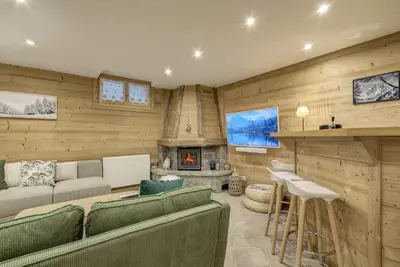 a living room with a couch and a fireplace at Mouilles - Apart 113m2 Jardin Calme Garage Bar Centre in Chamonix-Mont-Blanc