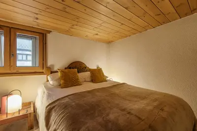 a bedroom with a large bed with a wooden ceiling at Cristal - Duplex Sauna Parking Remontee 300m Balcons in Chamonix-Mont-Blanc