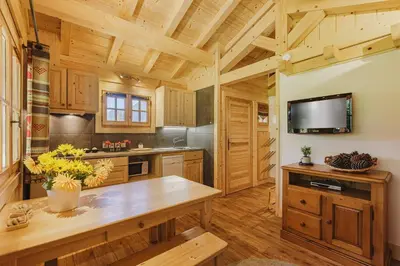 a kitchen with wooden cabinets and a large wooden table at Barrats Vert - Mazot Hypercentre 1km Nature Vues Calme in Chamonix-Mont-Blanc