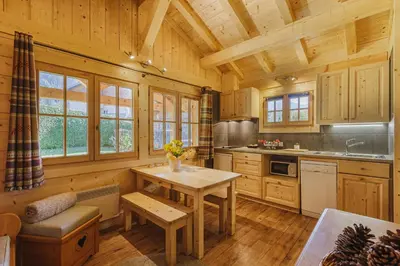 a kitchen with a table in a wooden cabin at Barrats Vert - Mazot Hypercentre 1km Nature Vues Calme in Chamonix-Mont-Blanc