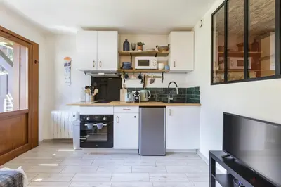 a kitchen with white cabinets and a stove top oven at Petit Balcon - Cosy 1CH Remontees 500m Vue Parking Calme in Les Houches