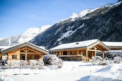 a log cabin in the snow with mountains in the background at Barrats Rouge - Mazot Hypercentre 1km Nature Vues Calme in Chamonix-Mont-Blanc
