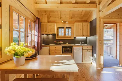 a kitchen with wooden cabinets and a wooden table at Barrats Rouge - Mazot Hypercentre 1km Nature Vues Calme in Chamonix-Mont-Blanc