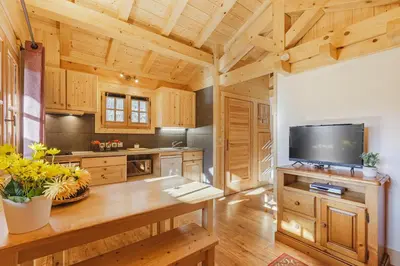 a kitchen with wooden cabinets and a flat screen tv at Barrats Rouge - Mazot Hypercentre 1km Nature Vues Calme in Chamonix-Mont-Blanc