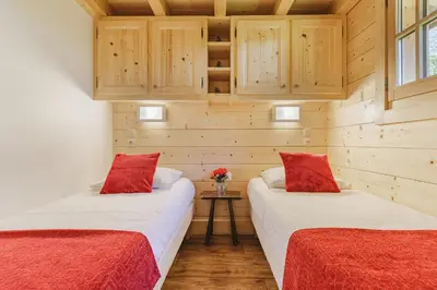 two beds in a room with wooden walls at Barrats Rouge - Mazot Hypercentre 1km Nature Vues Calme in Chamonix-Mont-Blanc