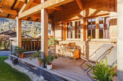 a house with a deck with chairs and a table at Barrats Rouge - Mazot Hypercentre 1km Nature Vues Calme in Chamonix-Mont-Blanc