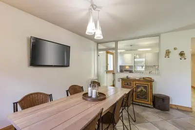 a dining room with a wooden table and a flat screen tv at Vallet - Spacieux Lumineux 100m2 Centre Vue Parking in Chamonix-Mont-Blanc