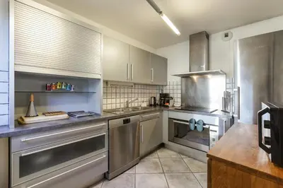 a large kitchen with stainless steel appliances at Vallet - Spacieux Lumineux 100m2 Centre Vue Parking in Chamonix-Mont-Blanc